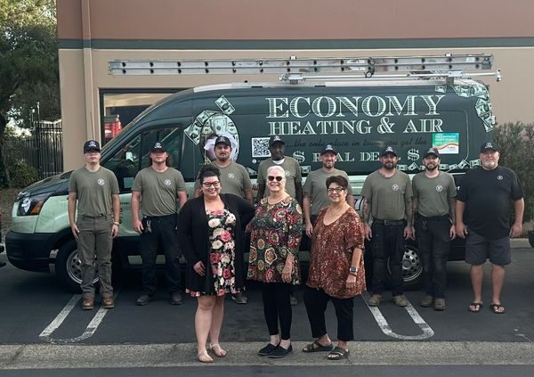 The Economy Heating and Air team in front of their service van